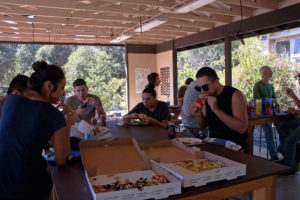 Volunteers eat pizza in the old outdoor classroom. Nancy Hamlett.