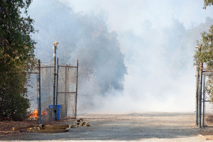 4:43 PM - The entry drive is filled with smoke as flames lick at what's left of the entry kiosk. Nancy Hamlett.