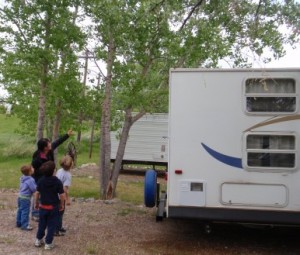 CHarlotte pointing out a robin\'s nest in the tree next to her trailer